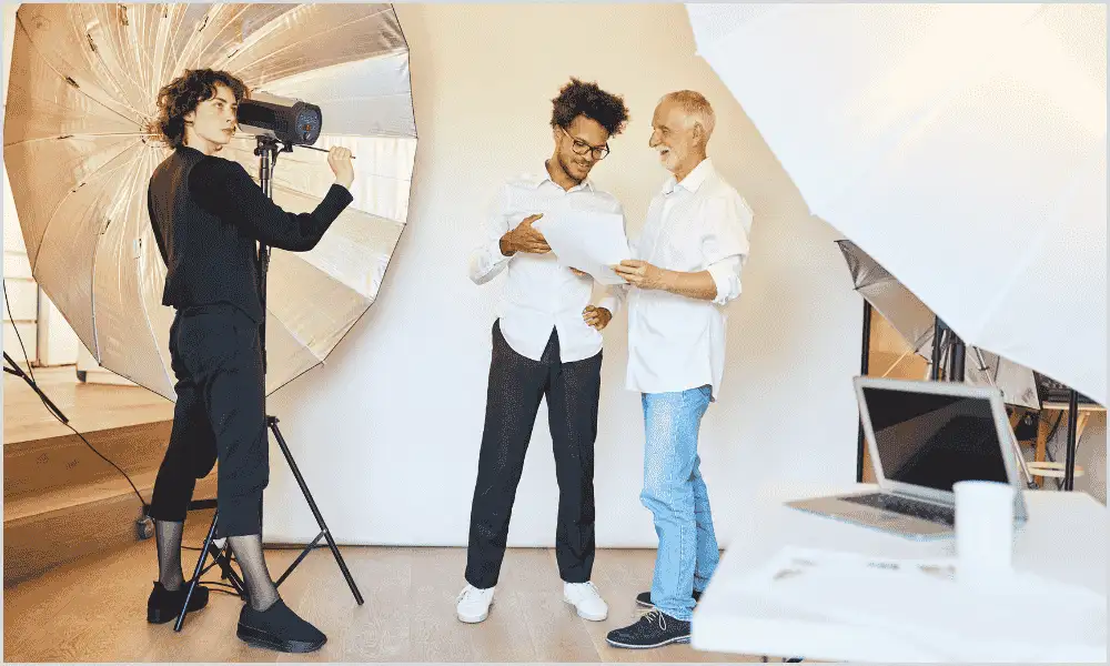 Photo assistant discussing with senior in studio, learning essential skills