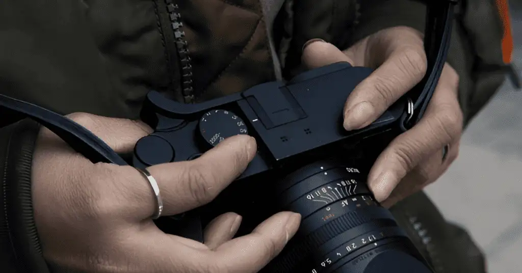 A man adjusting camera settings for night photography, preparing to capture stunning images in low-light conditions