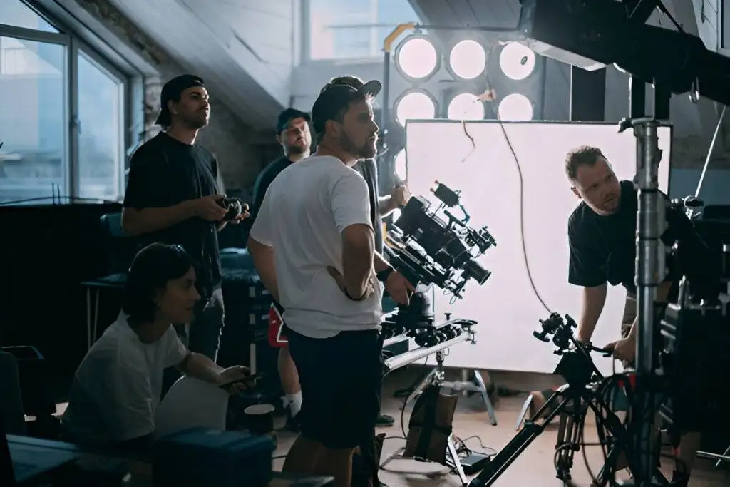 A group of photographers working together to adjust lighting, camera settings, and framing during a night photography session
