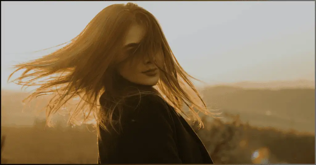 Girl turning her head to showcase her hair, captured with the Best Shutter Speed for Portraits to ensure sharpness in motion.