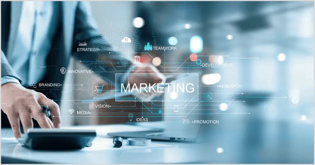 A person working on a laptop with a digital overlay displaying "MARKETING" and terms like strategy, branding, and promotion, illustrating how to find real estate buyers through niche advertising.