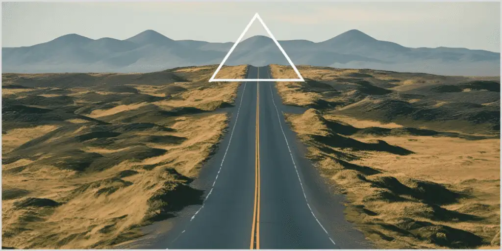 A road stretches into the distance with mountains in the background, overlaid with a white triangle to highlight implied triangle composition photography.