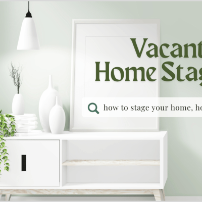 Minimalist vacant home staging with white console table, vases, and green plant under a pendant light, featuring a search bar for home styling ideas.