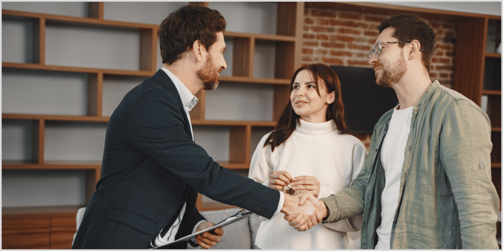 Real estate agent greeting couple while using open house scripts.