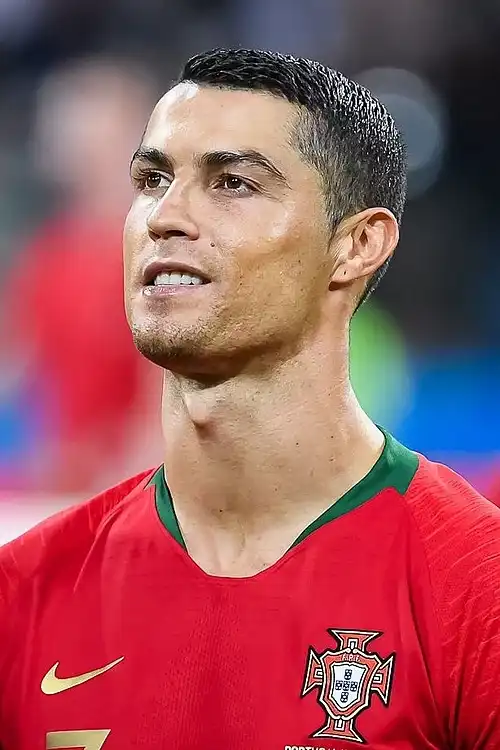 Cristiano Ronaldo in Portugal national team red jersey, intense gaze upward during match – Who Is The Most Photographed Person In The World